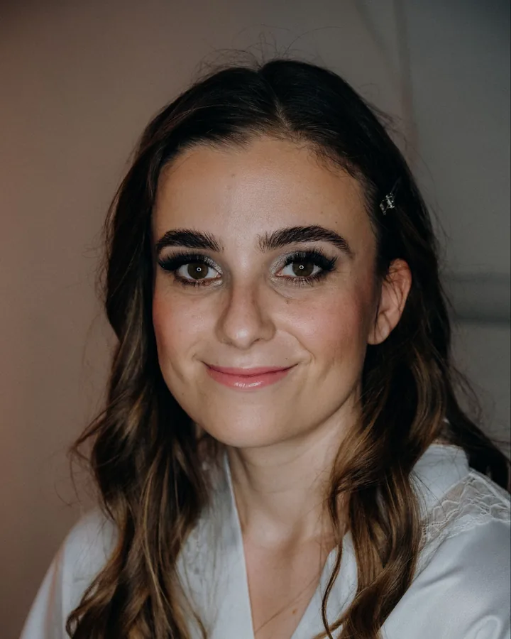 The same bride finished: defined brows, smoky lashes, peachy blush and a soft pink lip