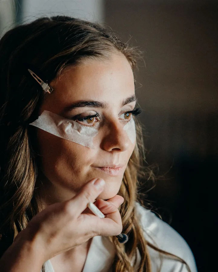 Bride with under-eye patches as her makeup is started