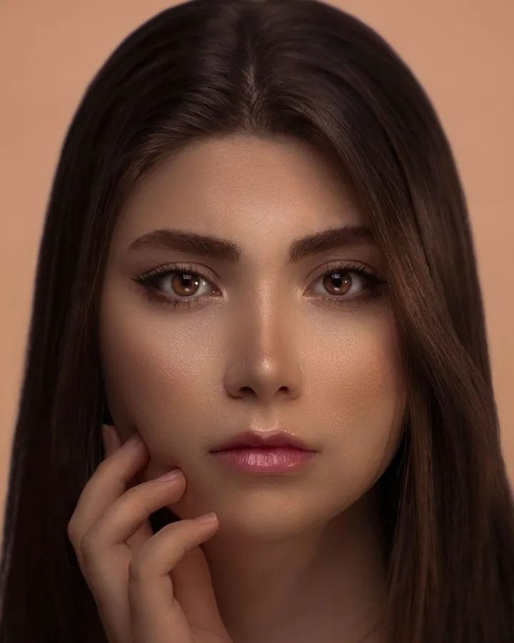 Model with a soft brown eye, full brows, warm bronzed skin and a rosy pink lip