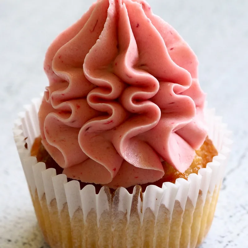 Cupcake with a tall ruffled swirl of strawberry-pink frosting