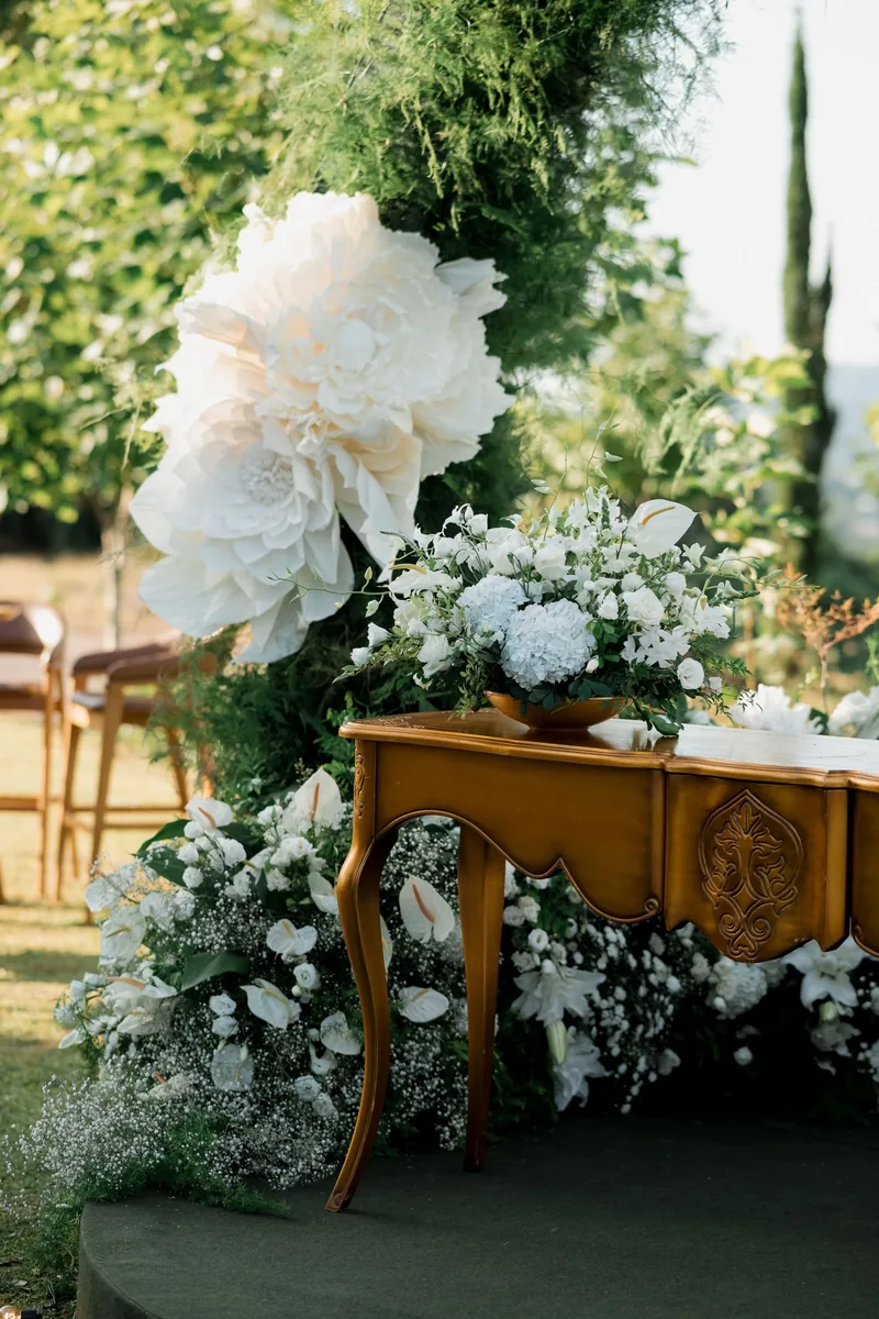 Close-up of the ceremony table: white hydrangea, lisianthus and baby's breath under a giant white bloom