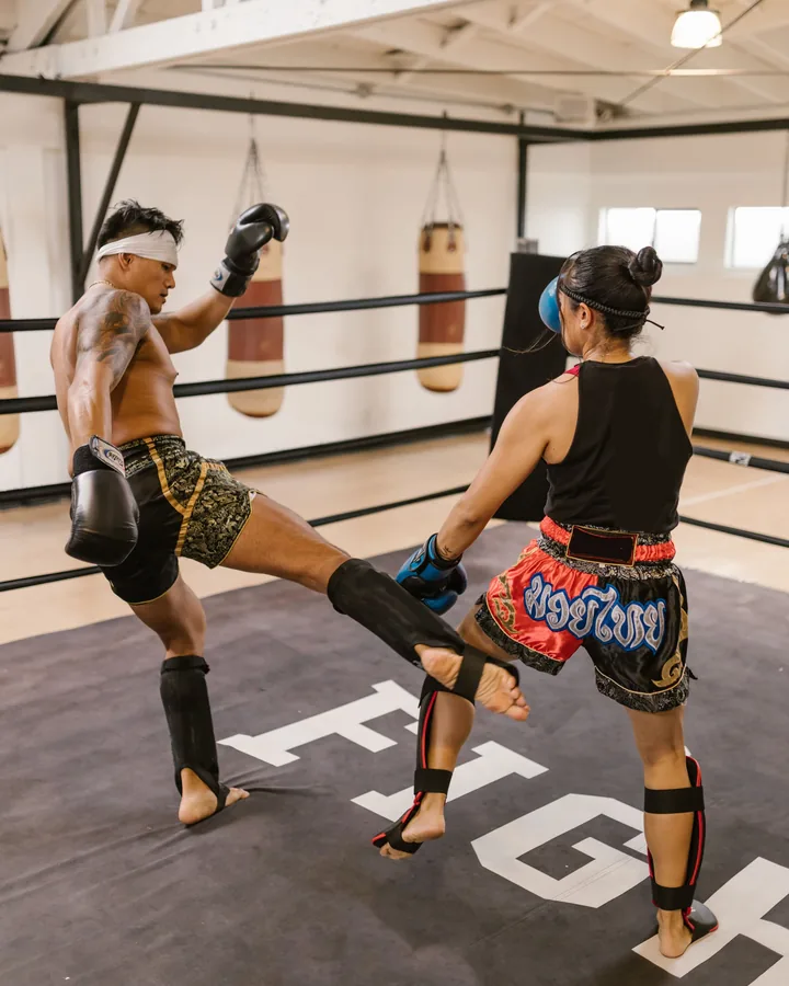 A mixed pair drilling kicks in shin guards
