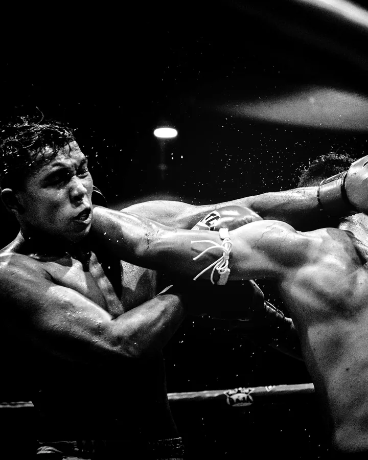 A punch lands during a sparring round, black and white