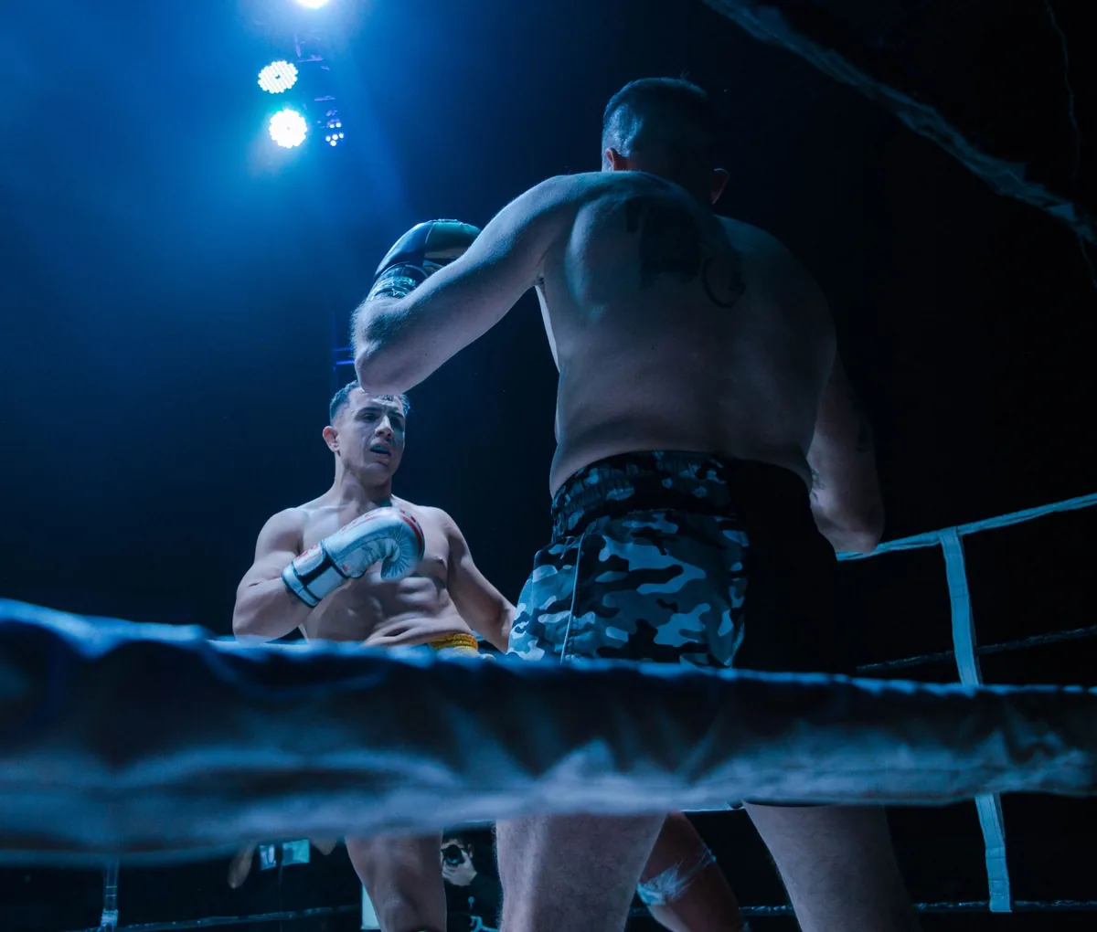Two fighters under the lights, seen from the ring apron