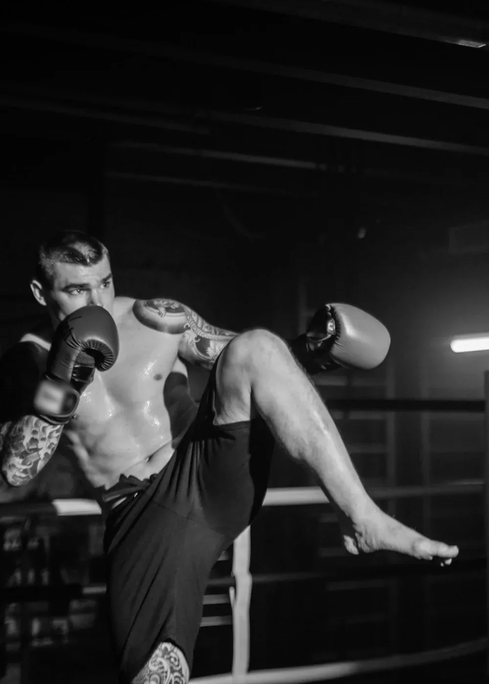 A knee strike drilled in the gym ring, black and white
