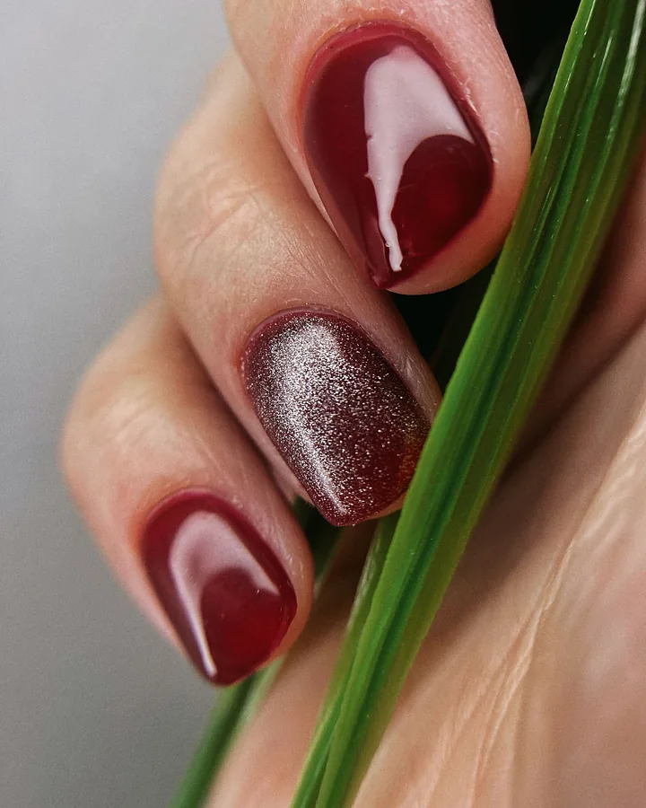 Deep cherry red nails with one glitter accent nail