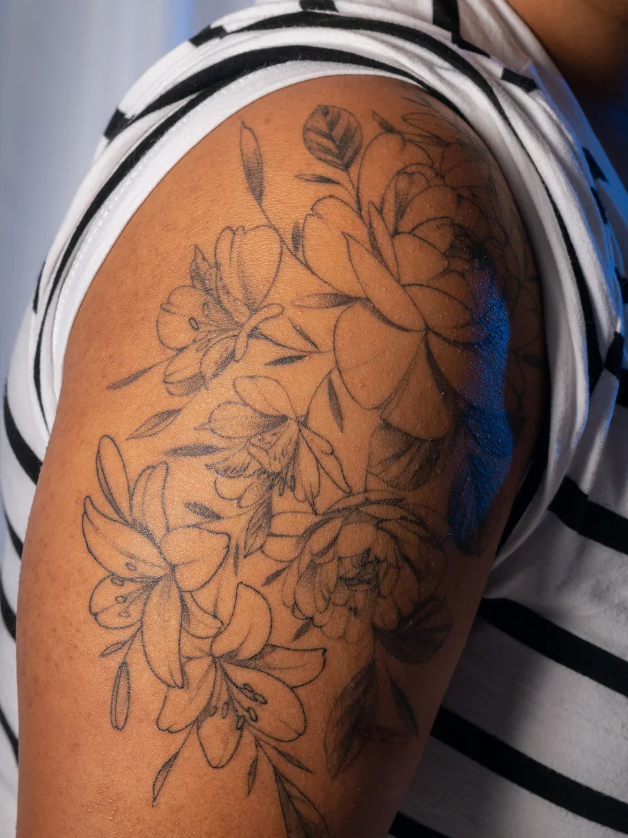 Fine line floral piece on a shoulder by Wren