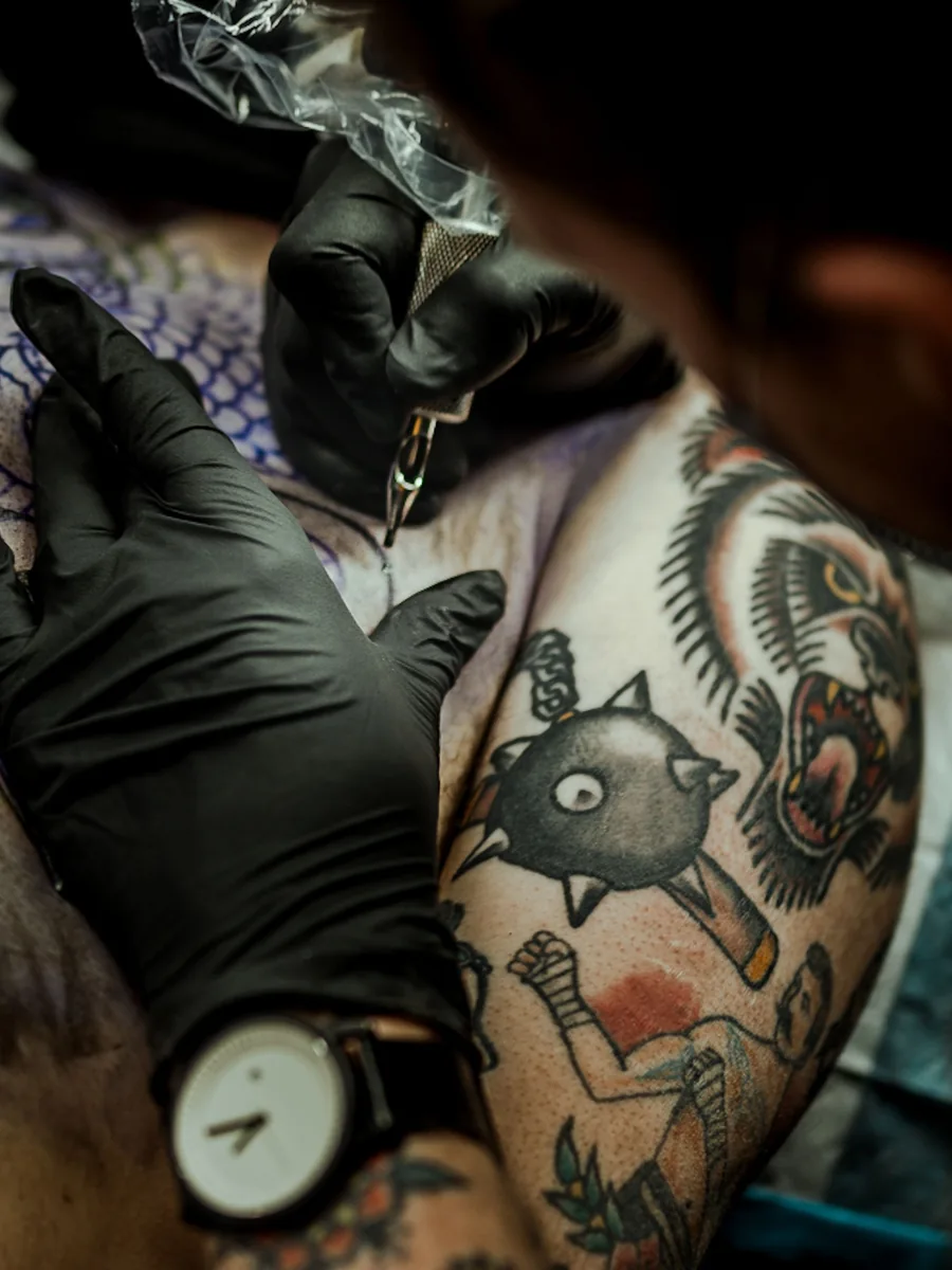 Bold traditional pieces on an upper arm, mid-session with Dex