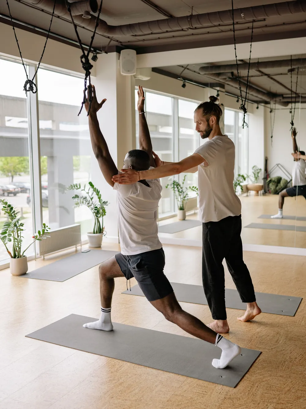 Theo guiding a student into a crescent lunge